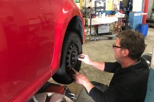Pierre Cadot, garagiste installe des pneus neige pour une cliente. 