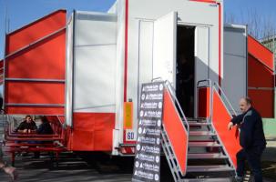 Un homme se tient devant le camion du Musée Mobile MuMo.