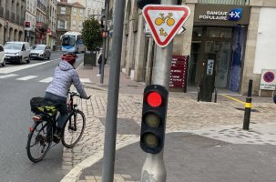 Le panneau M12 accorde le droit aux cyclistes à ne pas respecter le feu rouge.