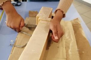 Une des jeunes qui découpe le savon