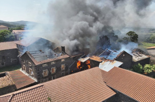 Les bâtiments sont en flamme et une épaisse fumée est visible de très loin