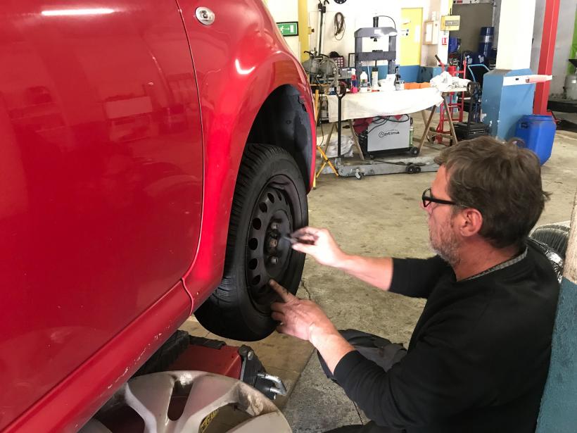 Pierre Cadot, garagiste installe des pneus neige pour une cliente. 