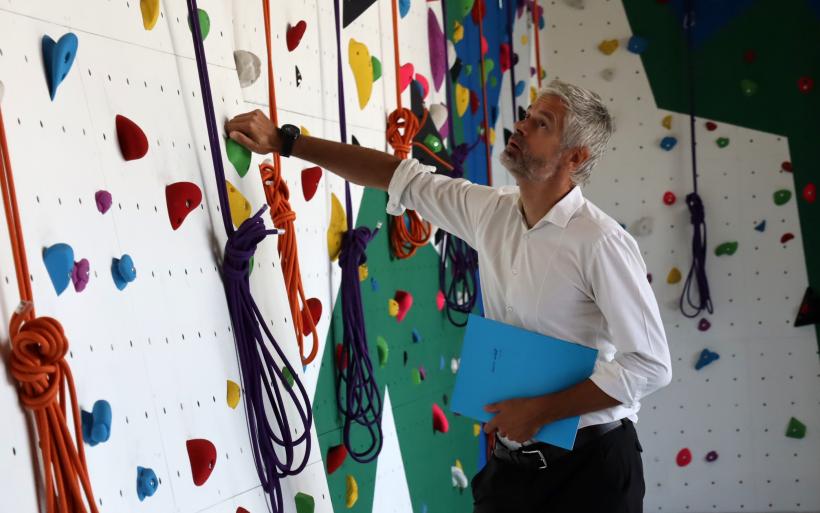 Le Président de la Région devant le mur d'escalade du lycée Jean-Monnet.