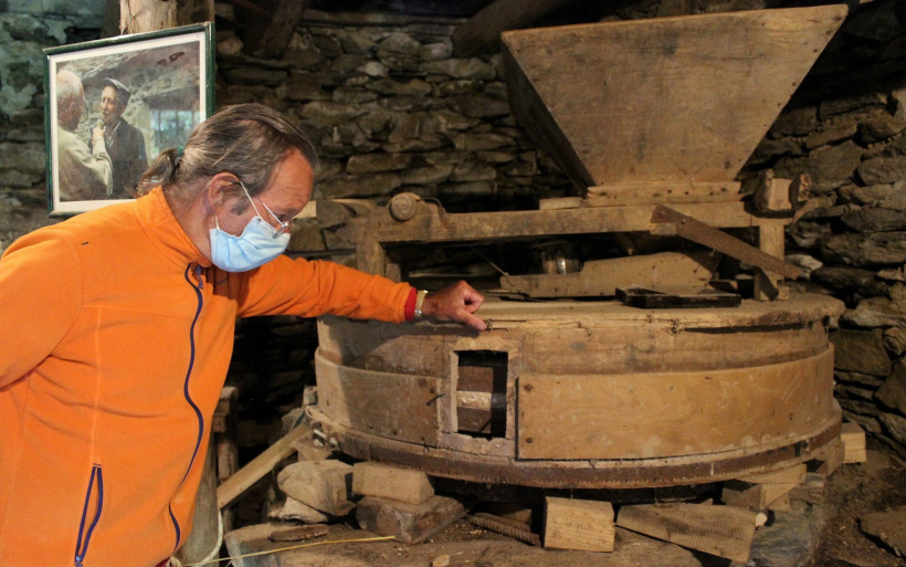 Alain Groisier devant la meule du moulin de Guérin à Saint-Julien-Chapteuil.