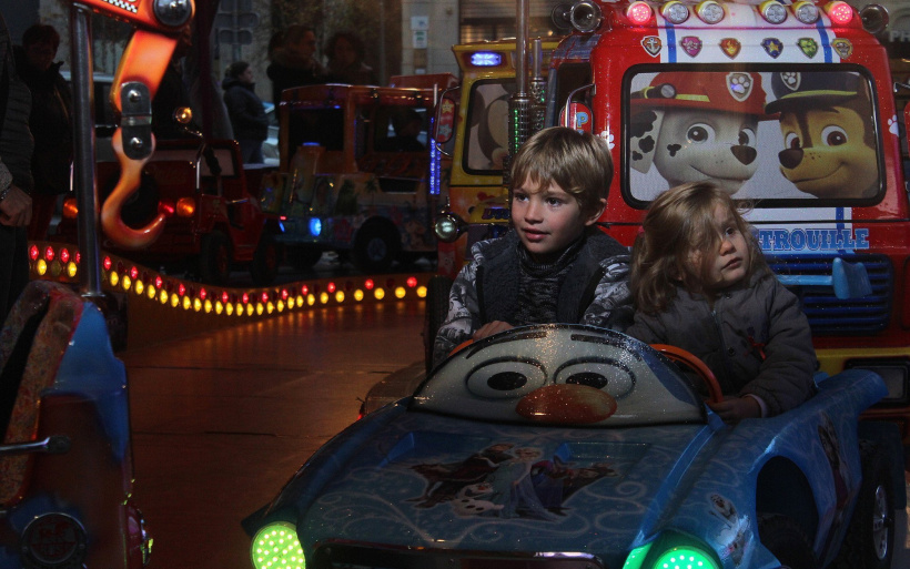 Des enfants dans un manège à la vogue du Puy