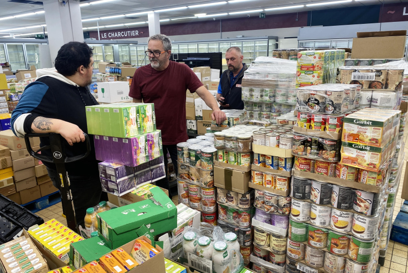 Avec ses collègues, Olivier, au centre, dispose les nouveaux produits Intermarché.