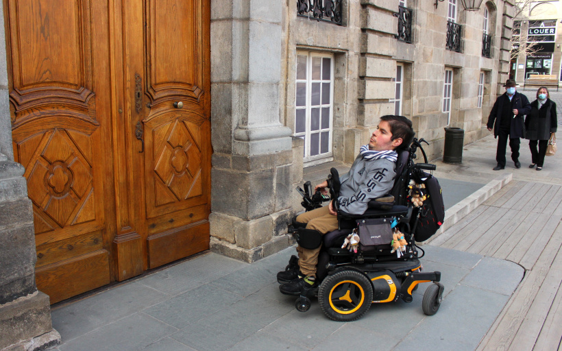 Face à la porte de l'Hôtel de ville, Quentin doit attendre qu'un passant ouvre la porte.