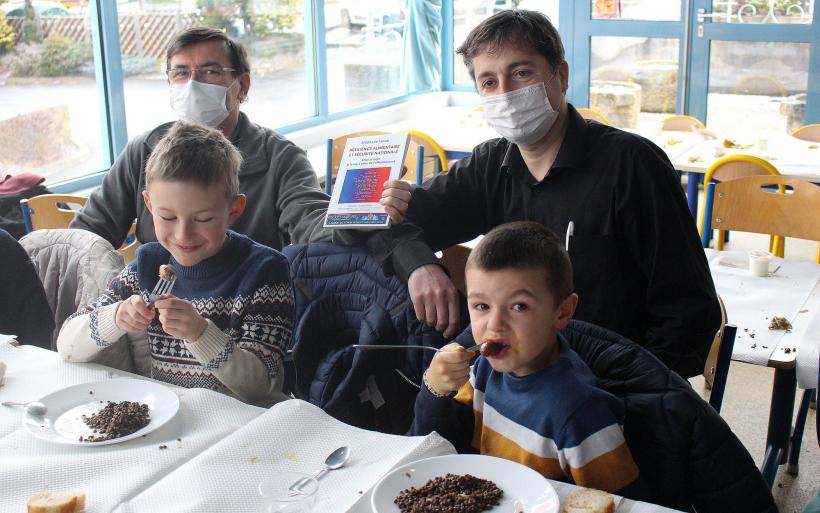 Guy Chapelle, Stéphane Linou (à droite) et des enfants ravis de leur repas local.