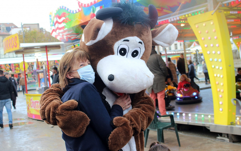 mascotte qui enserre une personne à la vogue du Puy