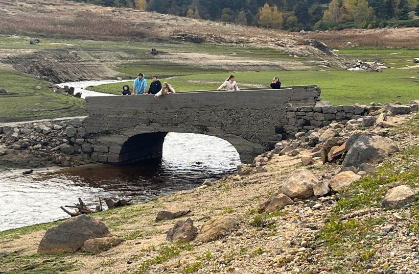 Un pont est resté debout, enjambant une antique rivière revenue à la vie. 