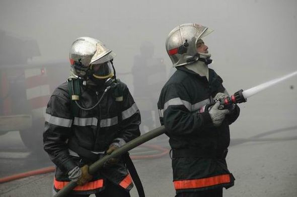 Des pompiers en train d'éteindre un incendie.