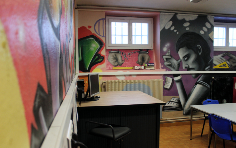 Dans une salle de cours, décorée par des détenus eux-même. 