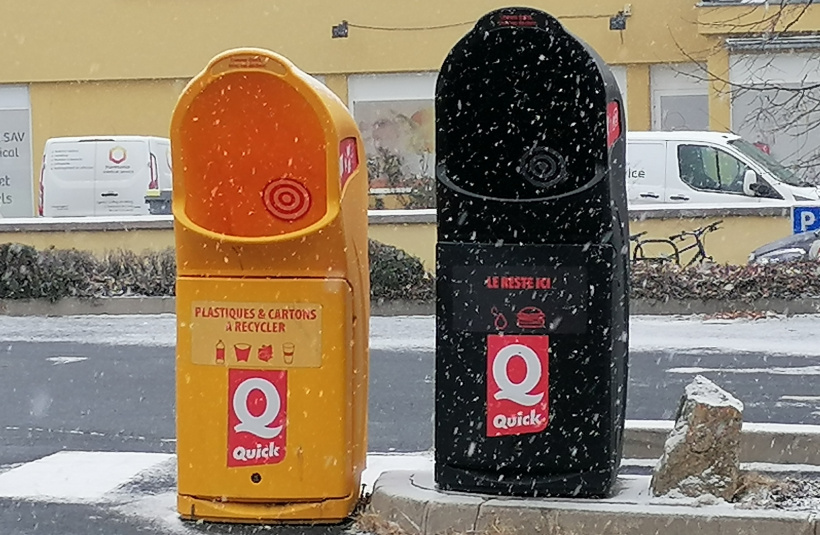 Les poubelles de tri à l'extérieur du Quick du Puy, mentionnant le plastique.