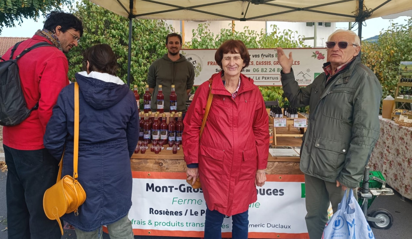 Des clients devant le stand des fruits rouges
