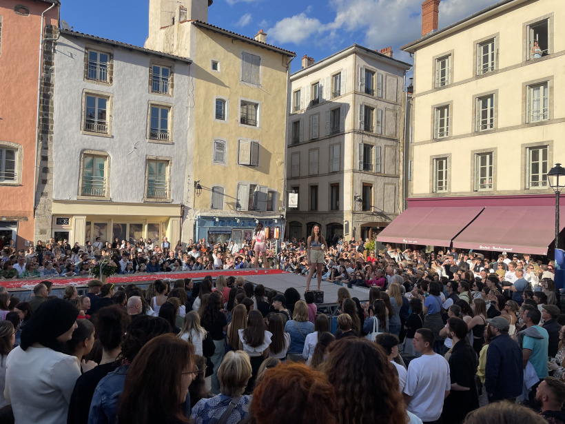 Foule avec les habitations de la place en arrière-plan