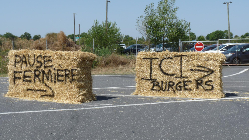 "Pause fermière". "Ici burgers" tagués sur des bottes de paille